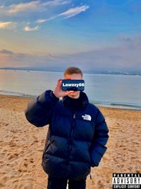 a man holding a phone on the beach