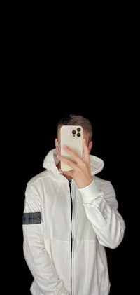 a man taking a selfie in a white hoodie